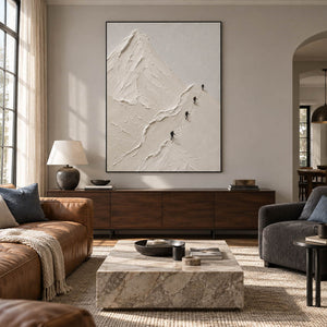 Four climbers ascending sculpted white mountain ridges in a vertical composition, displayed in a living room in a black frame.