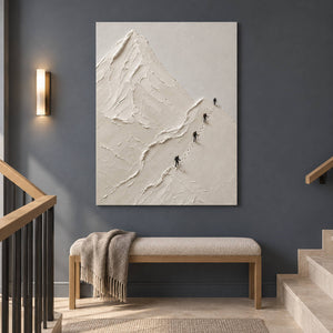 Four climbers ascending sculpted white mountain ridges in a vertical composition, displayed beside a staircase without an outer frame.