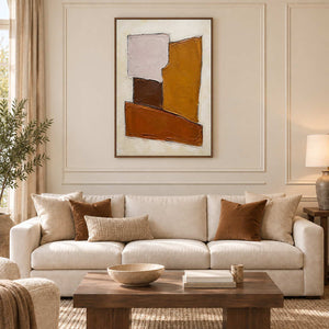 Close at Heart in a brown wood frame above a cream sofa, with ochre and brown geometric forms echoing warm room accents.