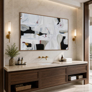 Wood framed white abstract artwork above a stone vanity in a bathroom dry area.