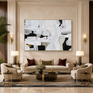 Gold framed white abstract artwork above cream seating in a warmly lit hotel lounge.