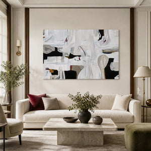 Frameless white abstract artwork with charcoal openings above a cream living room sofa.