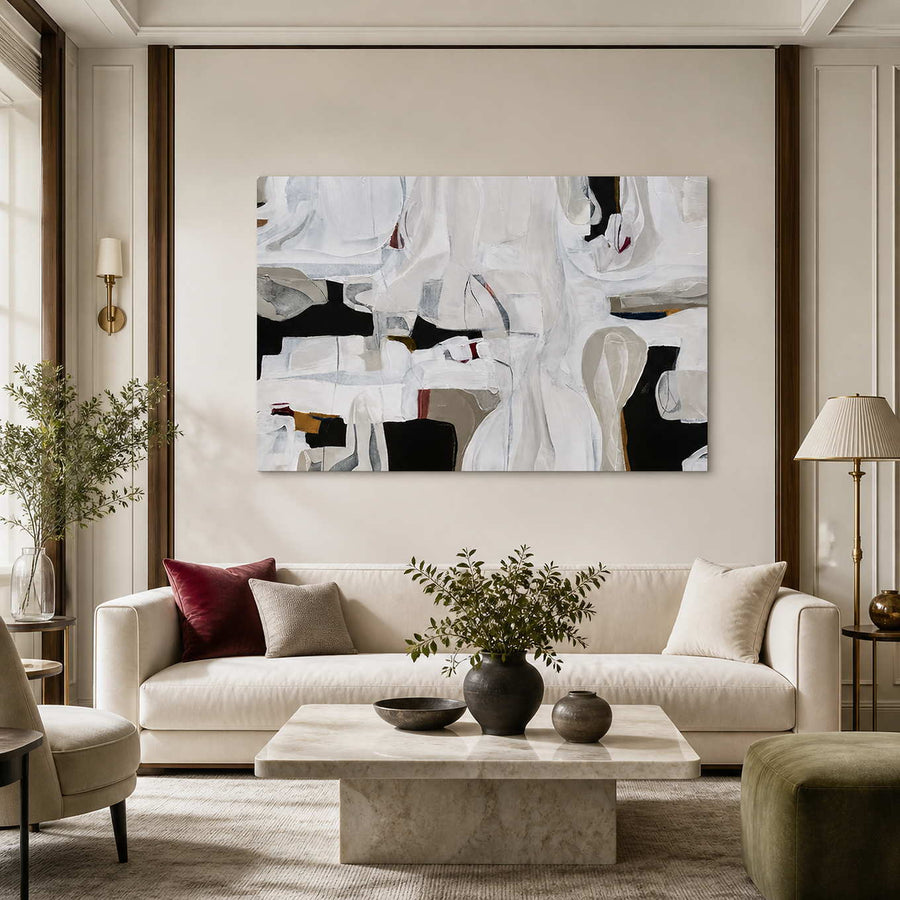 Frameless white abstract artwork with charcoal openings above a cream living room sofa.