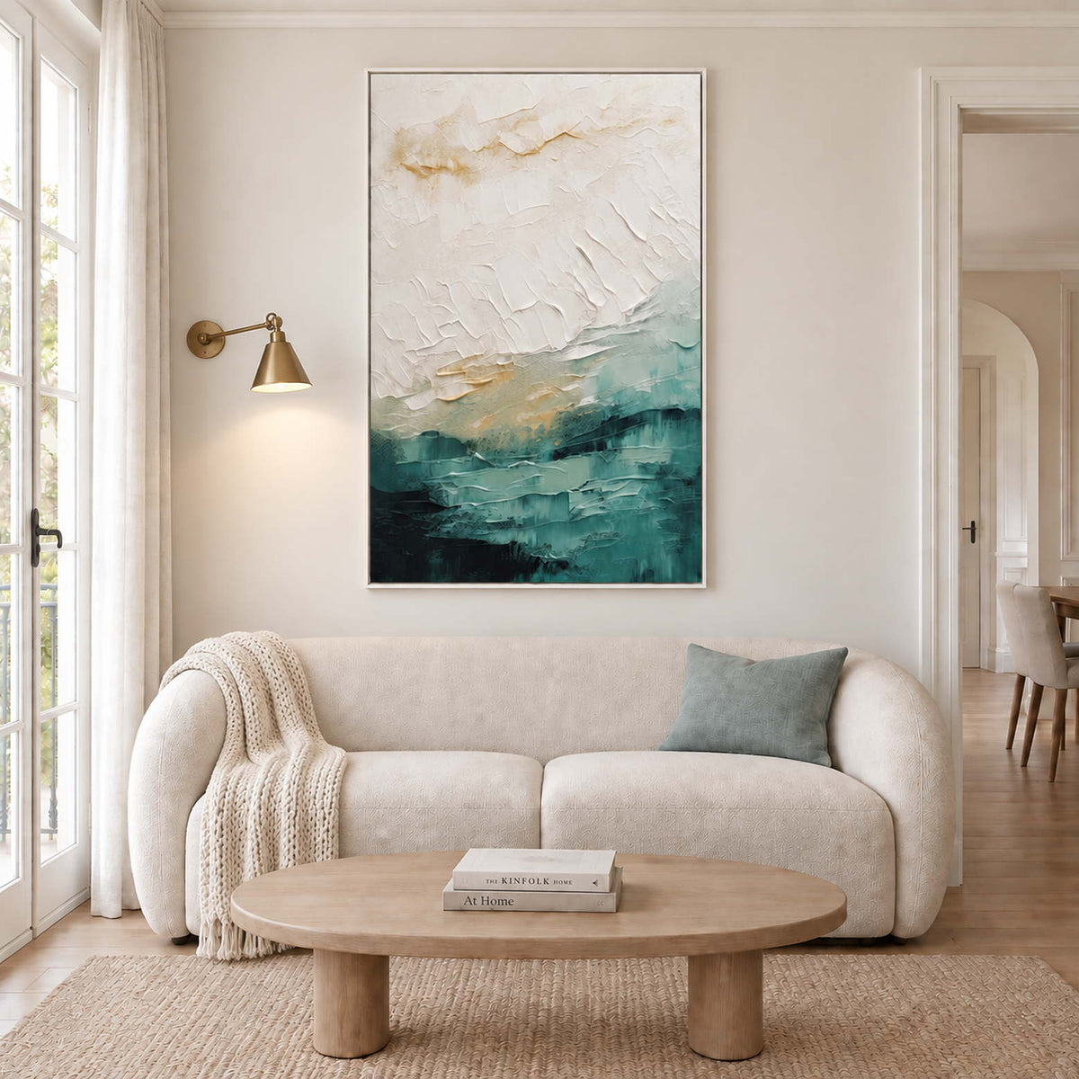 Raised ivory strokes above deep teal layers with gold accents in a white frame, displayed above a sofa in a living room.