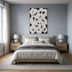 White framed curved brushwork above a linen bed against a blue gray wall.