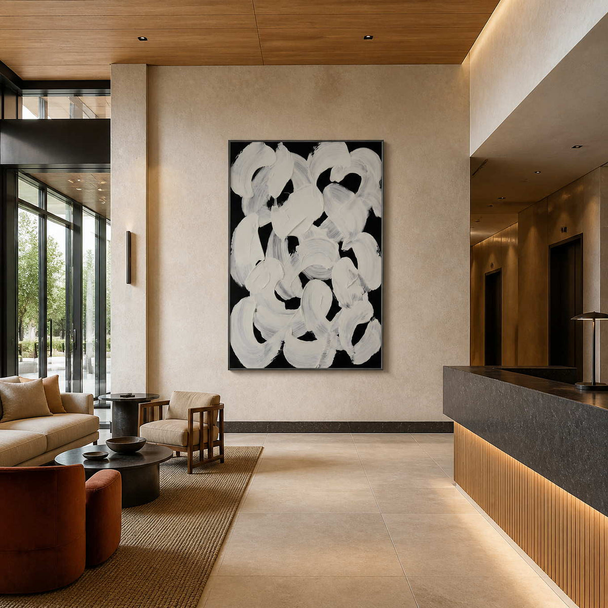 Black framed abstract loops above lobby seating near a long stone reception counter.