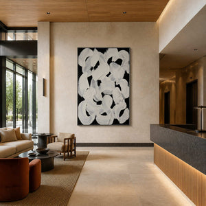 Black framed abstract loops above lobby seating near a long stone reception counter.