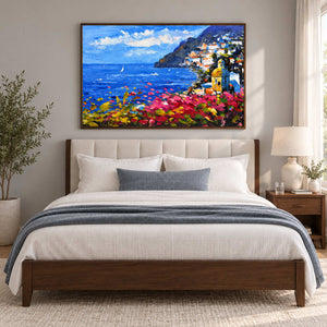 Coastal town artwork above a bed with blue-gray bedding.