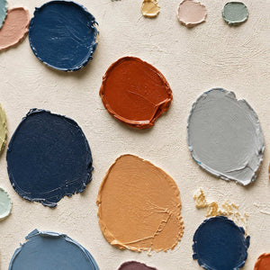 Close-up of raised navy, coral, sage, and gray palette-knife marks.