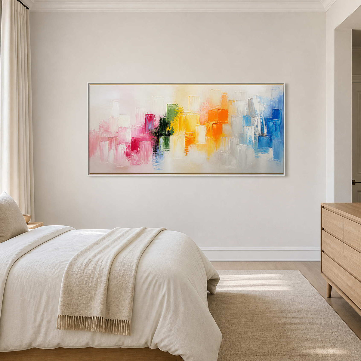 Wide multicolor abstract canvas above a serene ivory bedroom.