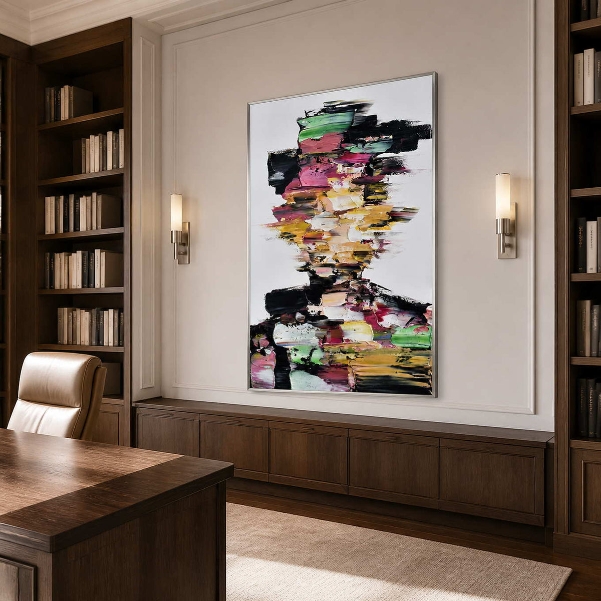 Silver framed colorful portrait between walnut bookshelves behind a wooden desk and leather chair.