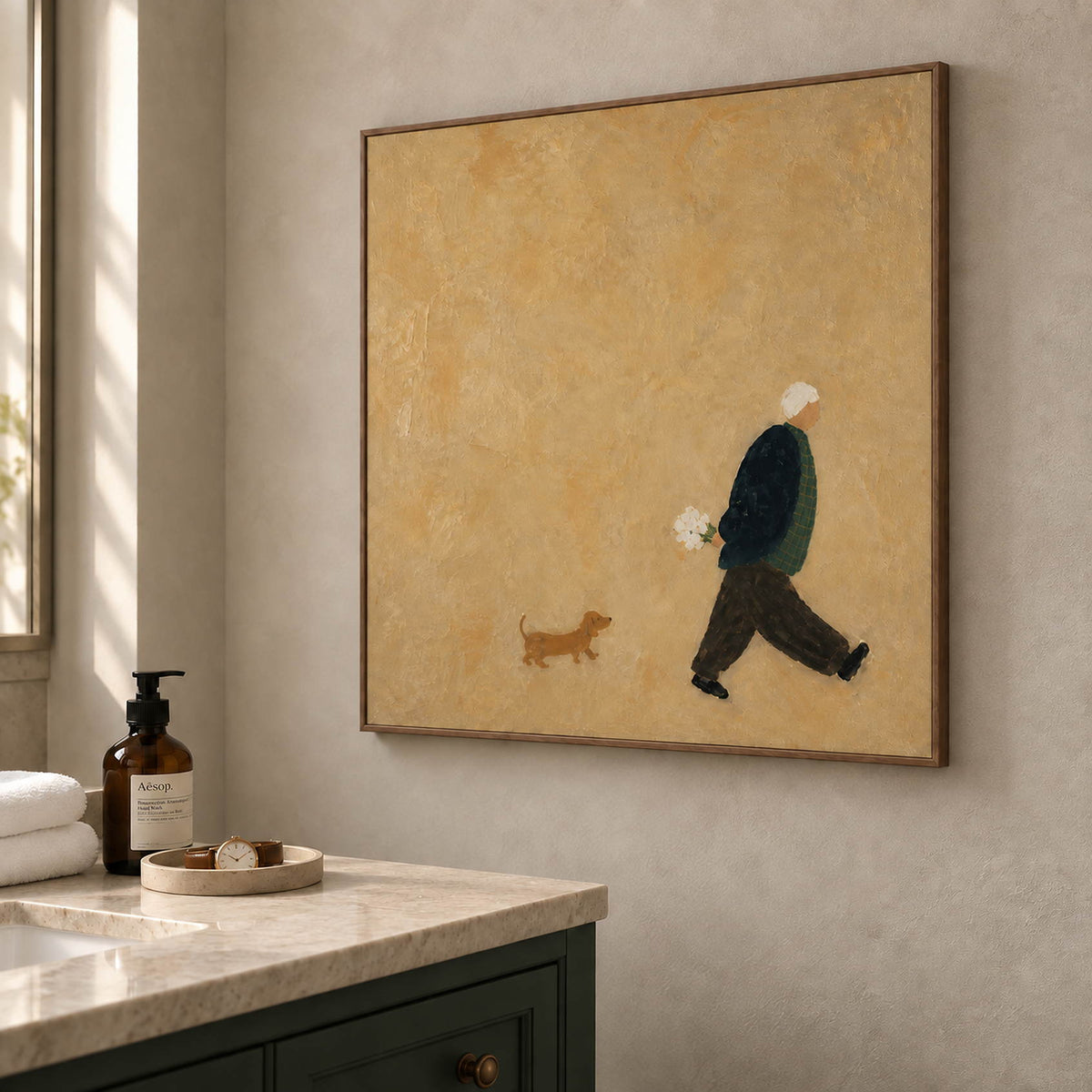 Ochre painting of a flower-carrying walker and a small brown dog in a brown wood frame beside a bathroom vanity.