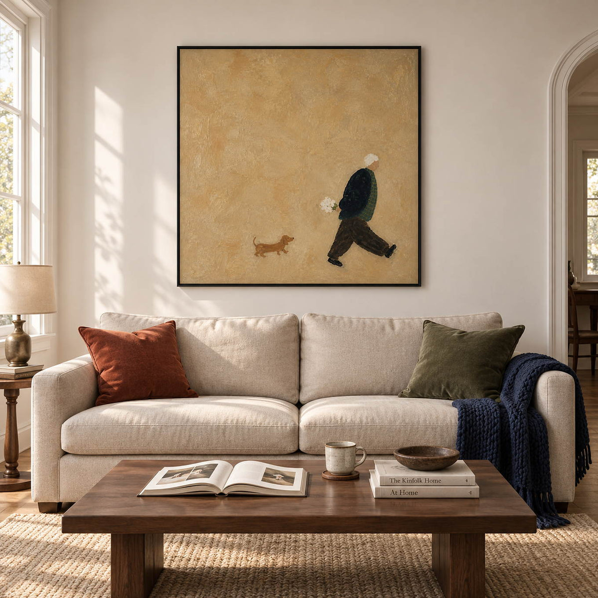 Ochre painting of a flower-carrying walker and a small brown dog in a black frame in a living room.