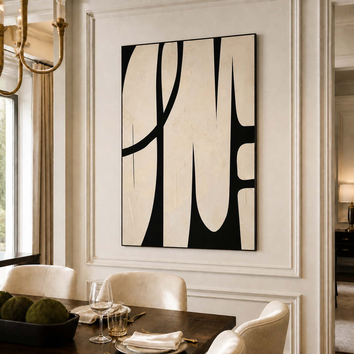 Black framed cream abstract artwork above a dark dining table set with glasses and plates.