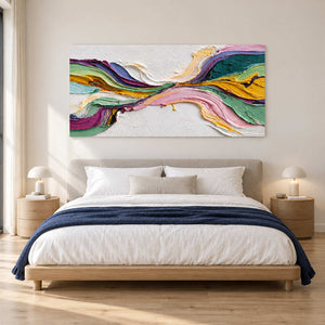Colorful ribbon painting above a bed with a navy throw.