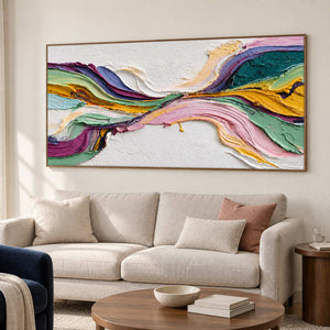 Angled view of ribbon artwork above a sofa with pink cushions.