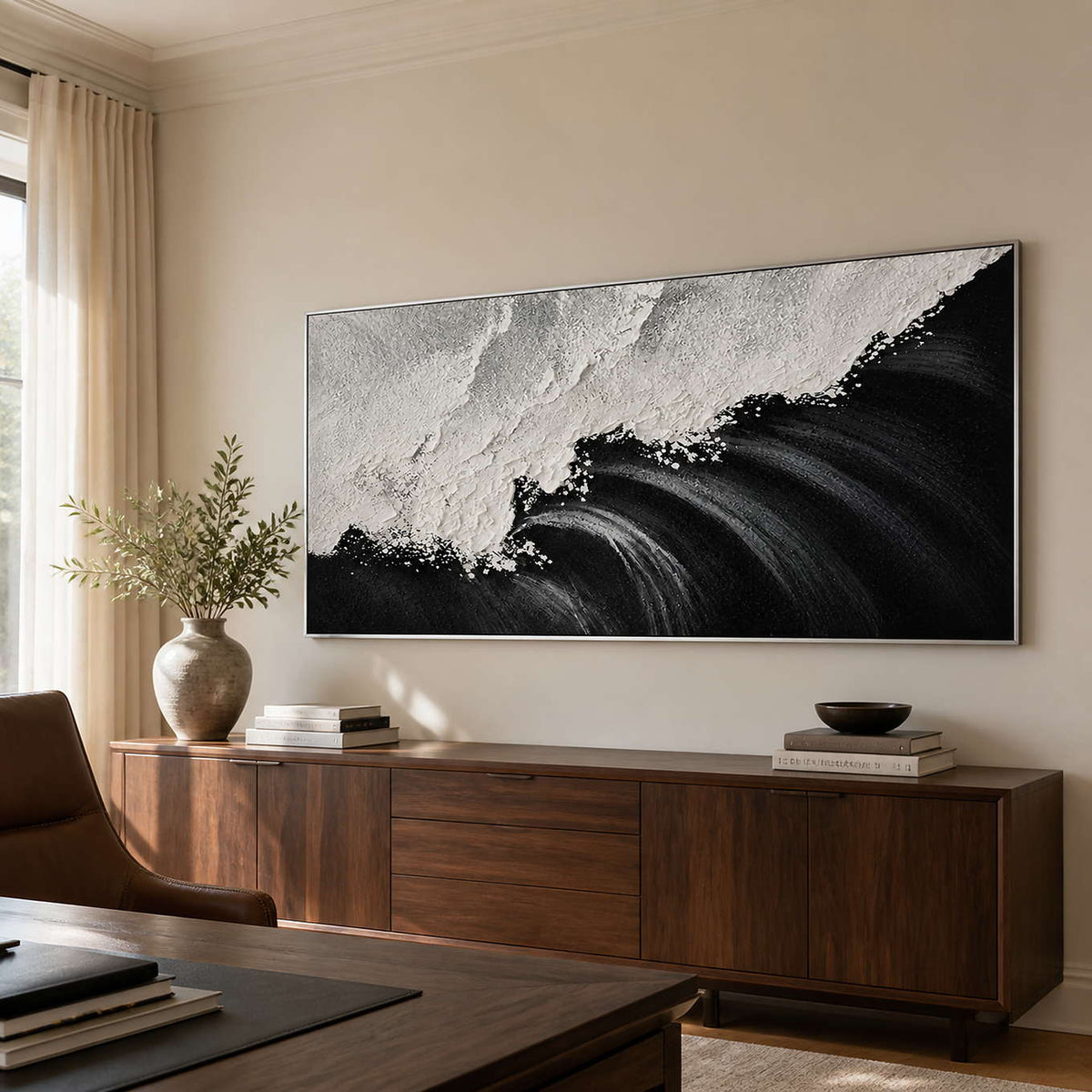 Silver framed wave painting with sweeping dark curves above a walnut office cabinet.