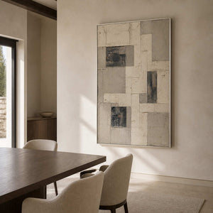 Architectural neutral wall art in a modern dining room with a silver frame.