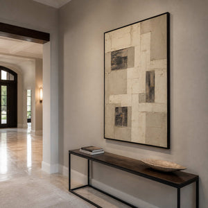 Textured geometric wall art in an elegant entryway with a black frame.