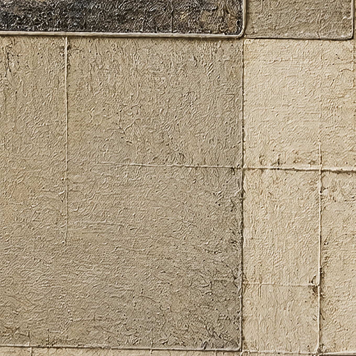 Close-up of scored ivory rectangles and weathered charcoal surface texture.