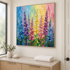 Tall purple, pink and yellow flowers against a bright pastel background in a silver frame, displayed in a bathroom dry area.