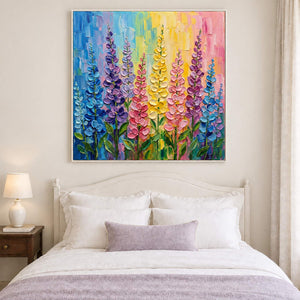 Tall purple, pink and yellow flowers against a bright pastel background in a white frame, displayed above a bed.