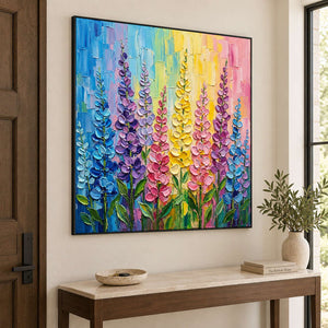 Tall purple, pink and yellow flowers against a bright pastel background in a black frame, displayed above an entryway console.