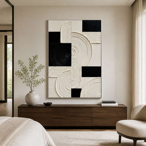 Silver framed black and cream artwork above a walnut bedroom dresser.