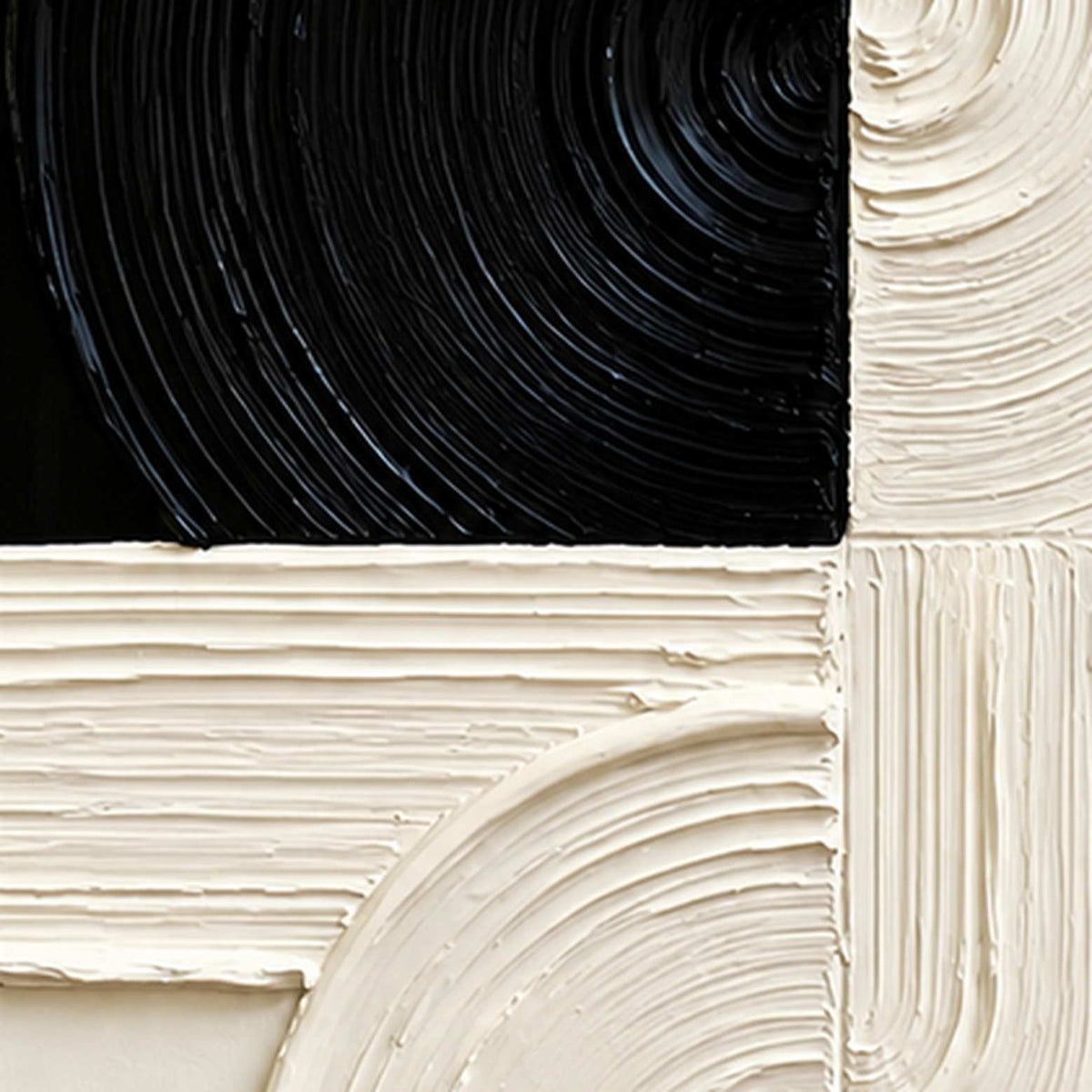 Close view of combed circular grooves crossing black and cream paint blocks.