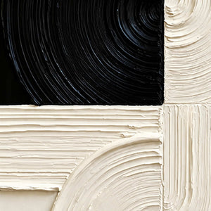 Close view of combed circular grooves crossing black and cream paint blocks.