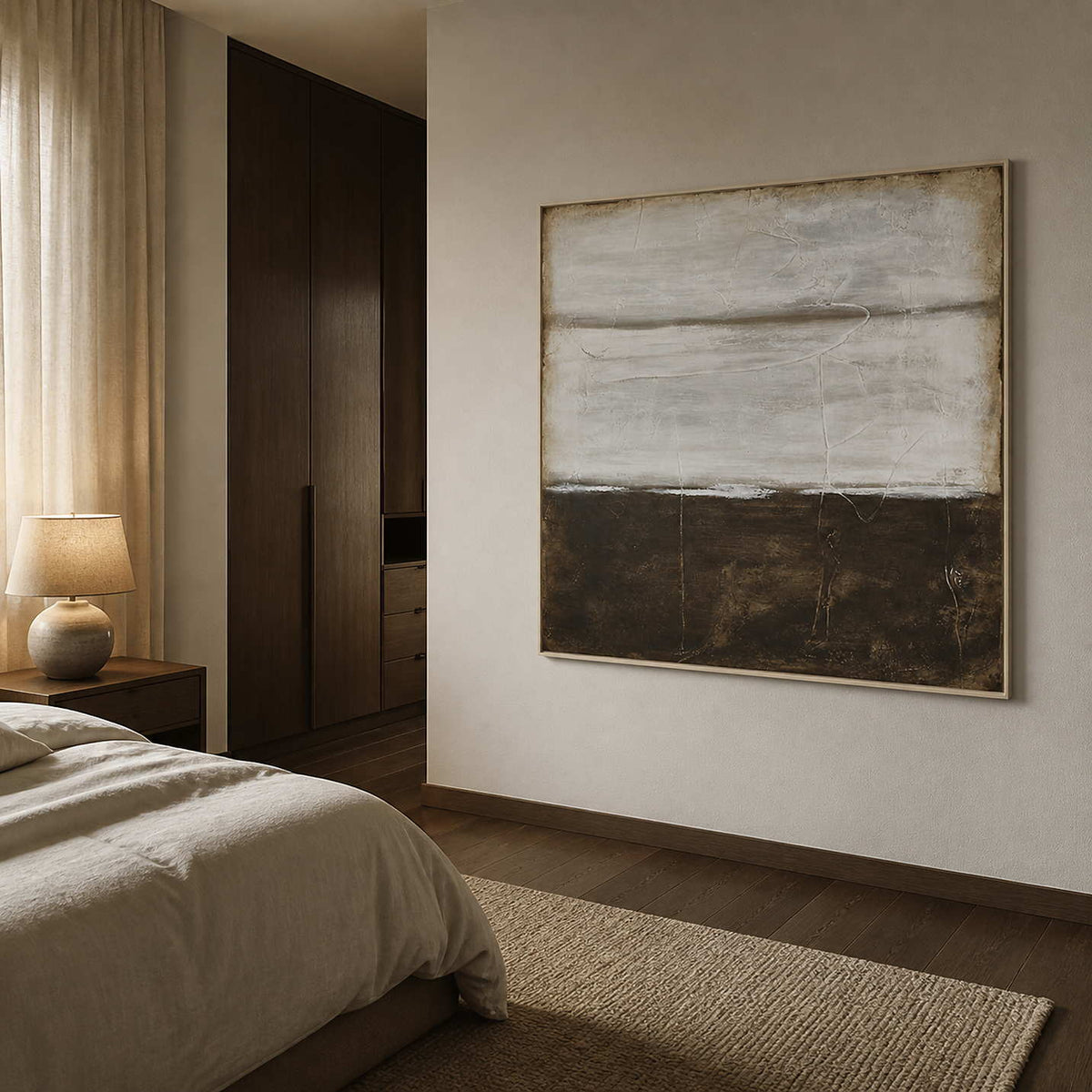 White-framed gray and brown abstract beside a neutral bed and dark wooden wardrobe.