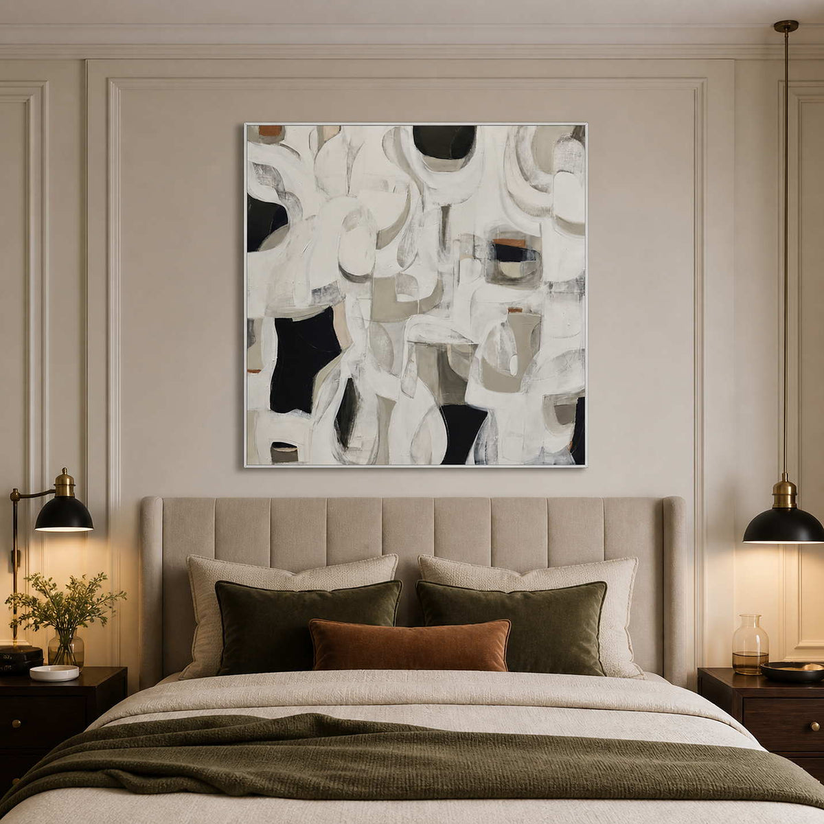 White framed square abstract artwork above a neutral bed with olive and rust cushions.