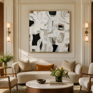 Gold framed square abstract artwork above curved cream seating in a hotel lounge.