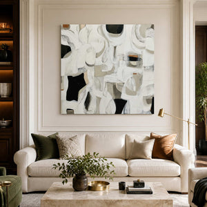 Frameless square abstract artwork with white curves above a cream living room sofa.