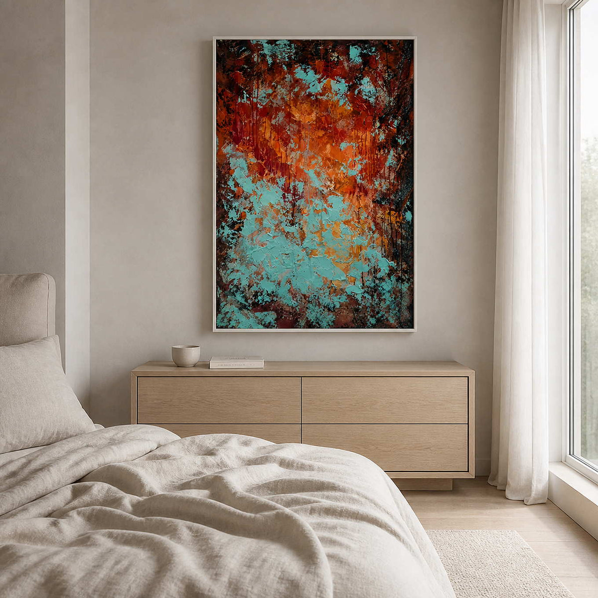 White framed richly colored abstract painting above a dresser beside a bed.