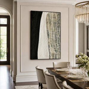 Black framed abstract artwork beside a wooden dining table with white upholstered chairs.