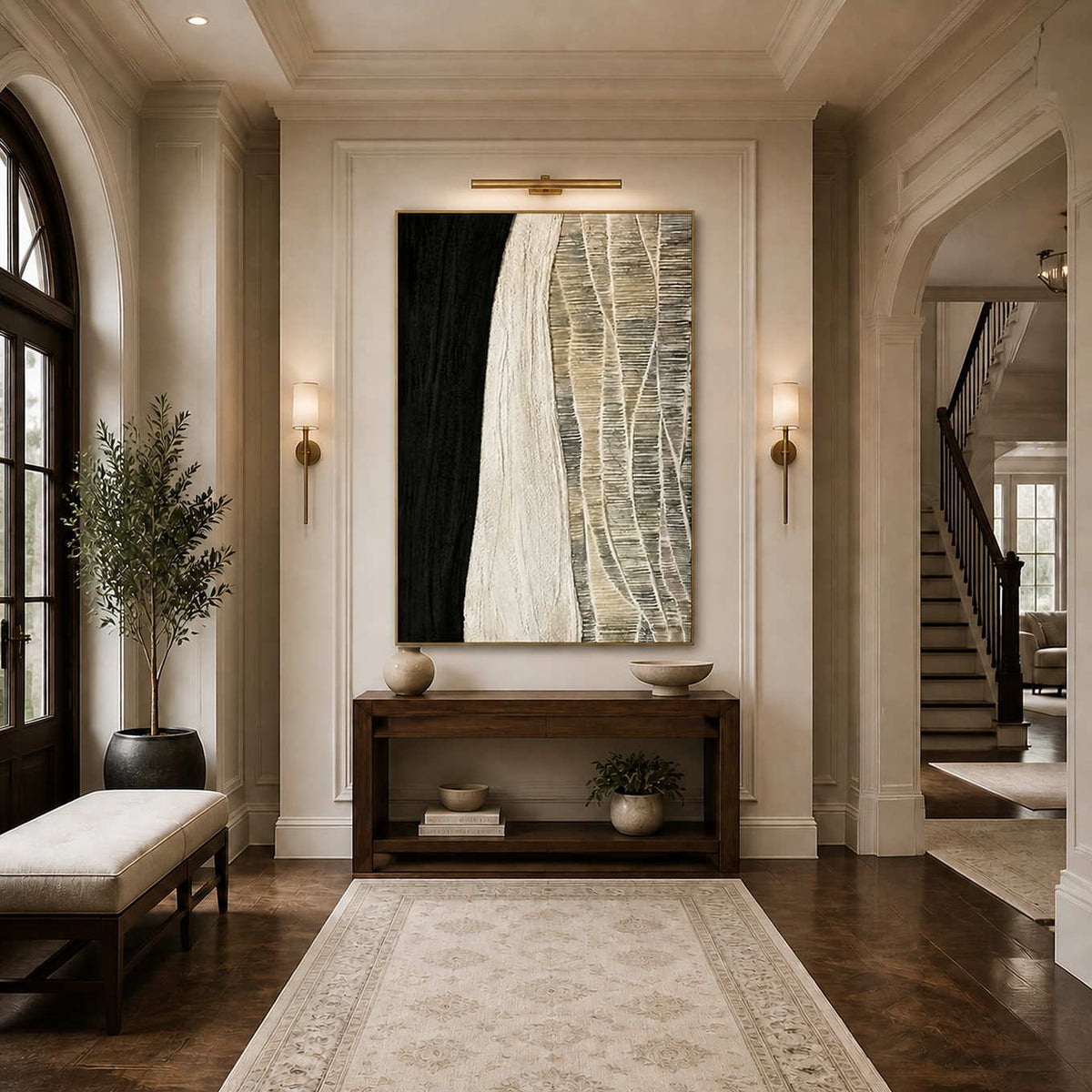 Gold framed black and cream artwork above a dark console in an arched hallway.