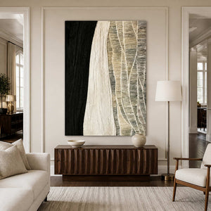 Frameless black and cream artwork above a dark cabinet in a bright living room.