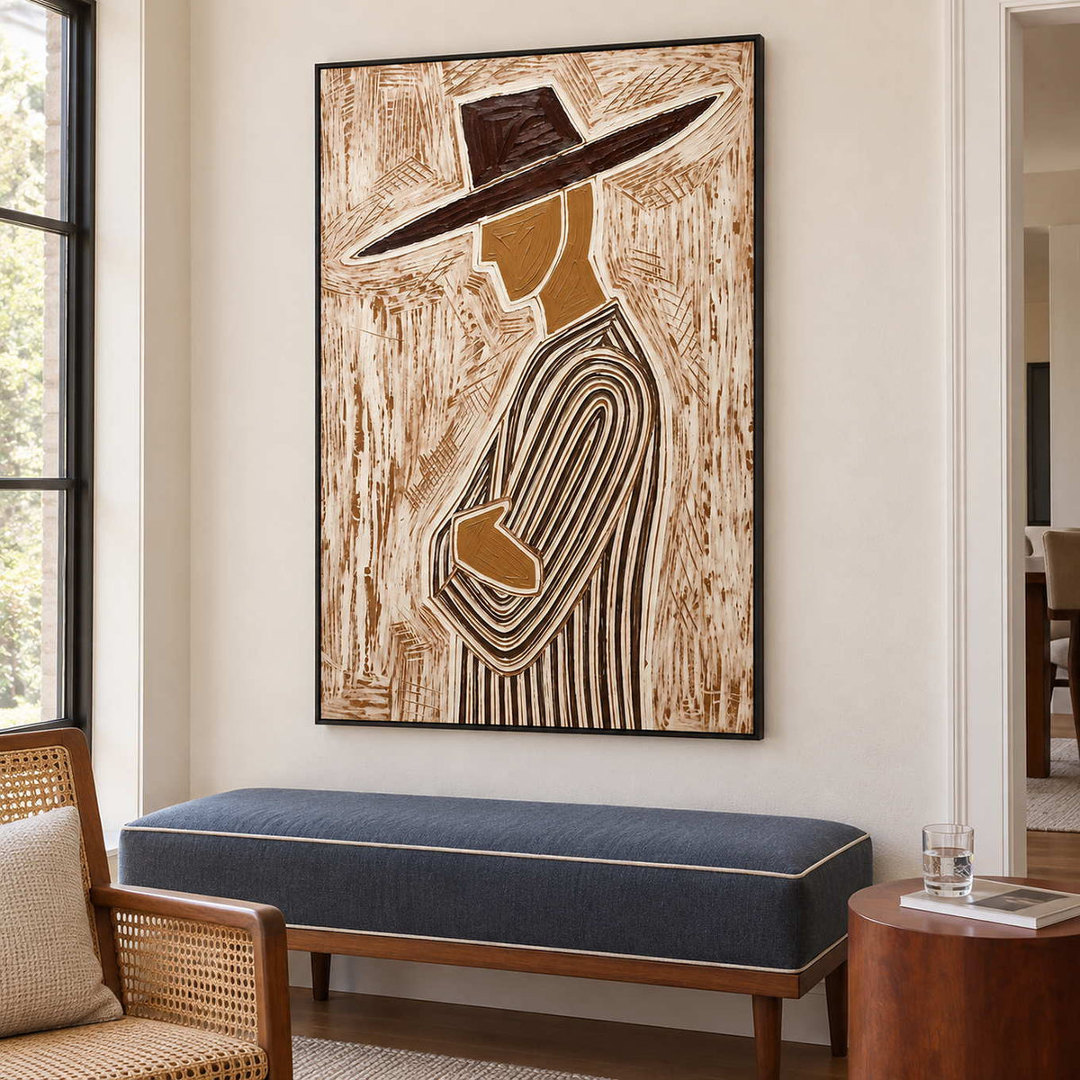 Left-facing figure artwork above a navy bench near a window and small side table.
