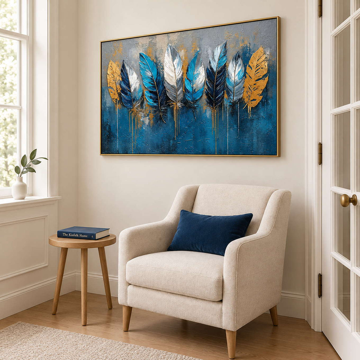 Blue, white and gold feathers against a deep blue and gray background in a gold frame, displayed beside seating in a lounge.