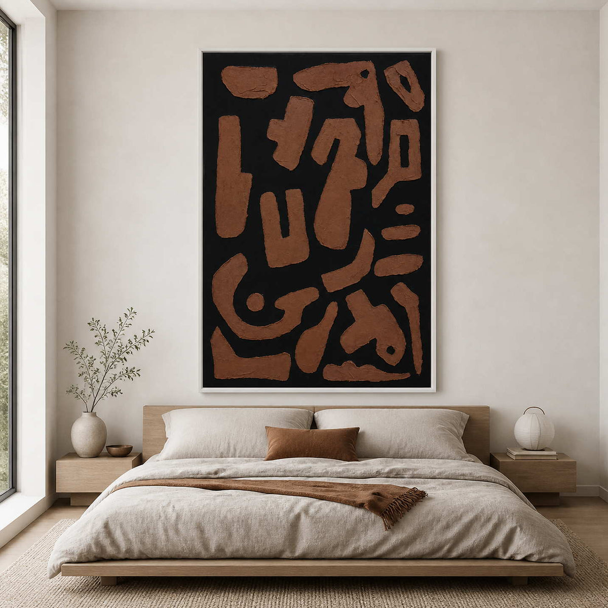 White framed geometric abstract painting above a wooden bed with neutral bedding.