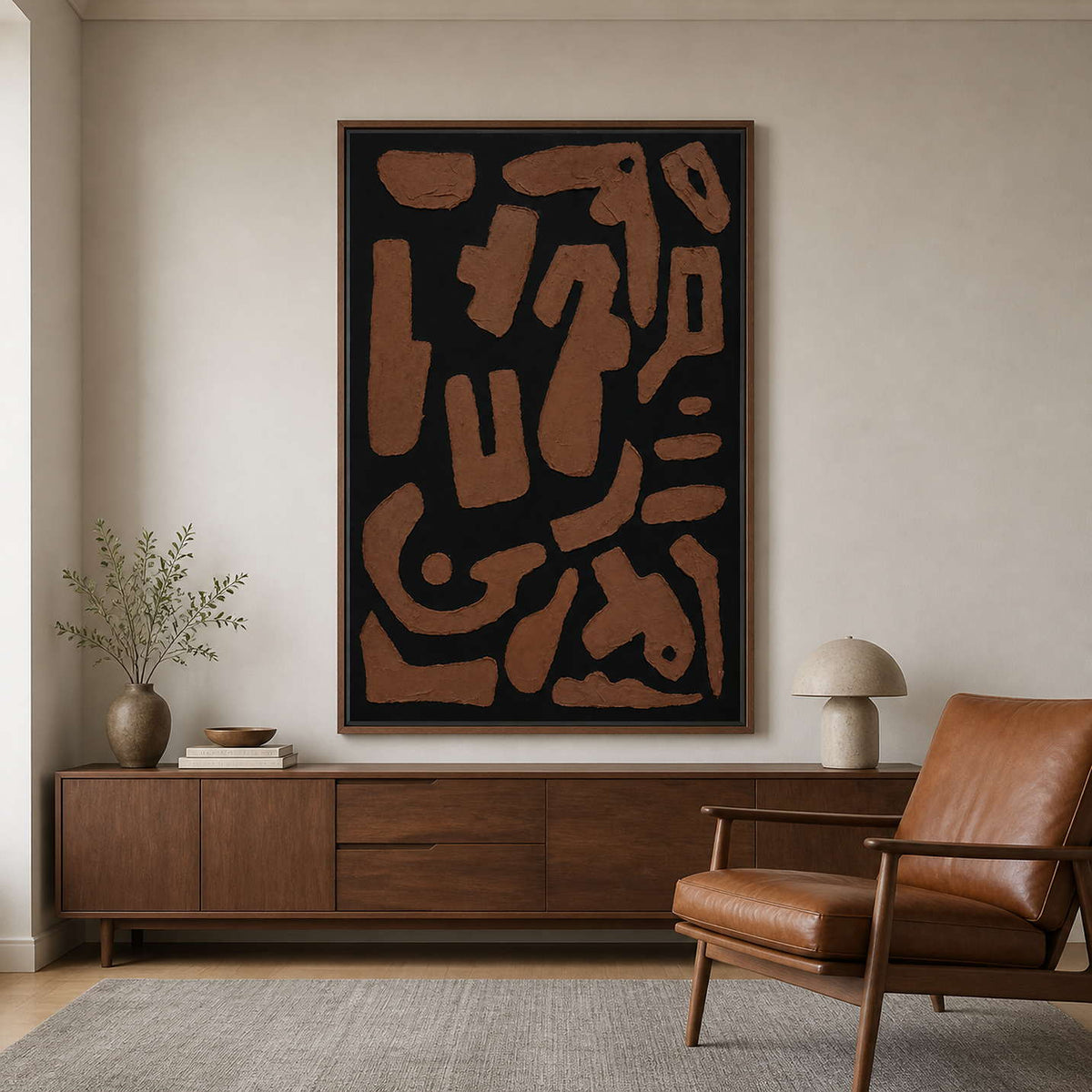 Wood framed rust and black painting beside a leather reading chair.