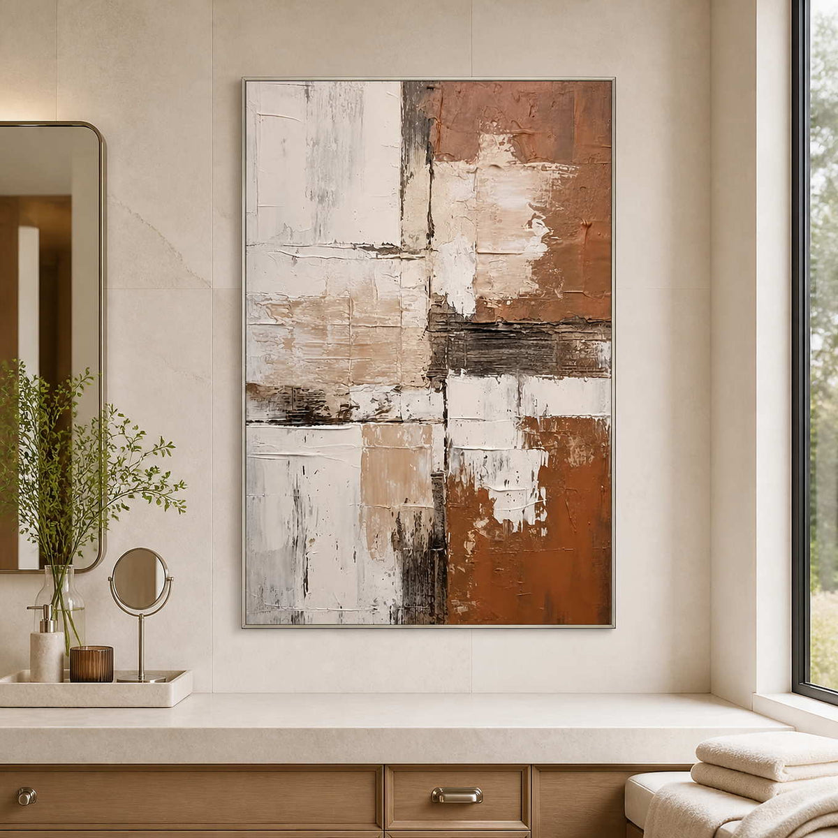 Silver-framed terracotta abstract wall art above a bathroom vanity beside a window.