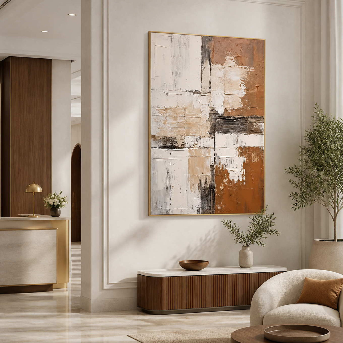 Gold-framed abstract wall art above a fluted console in a hotel lobby.