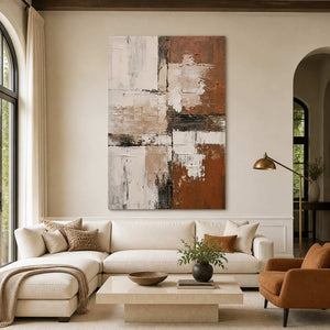 Terracotta and cream abstract wall art above a sofa in a warm living room.