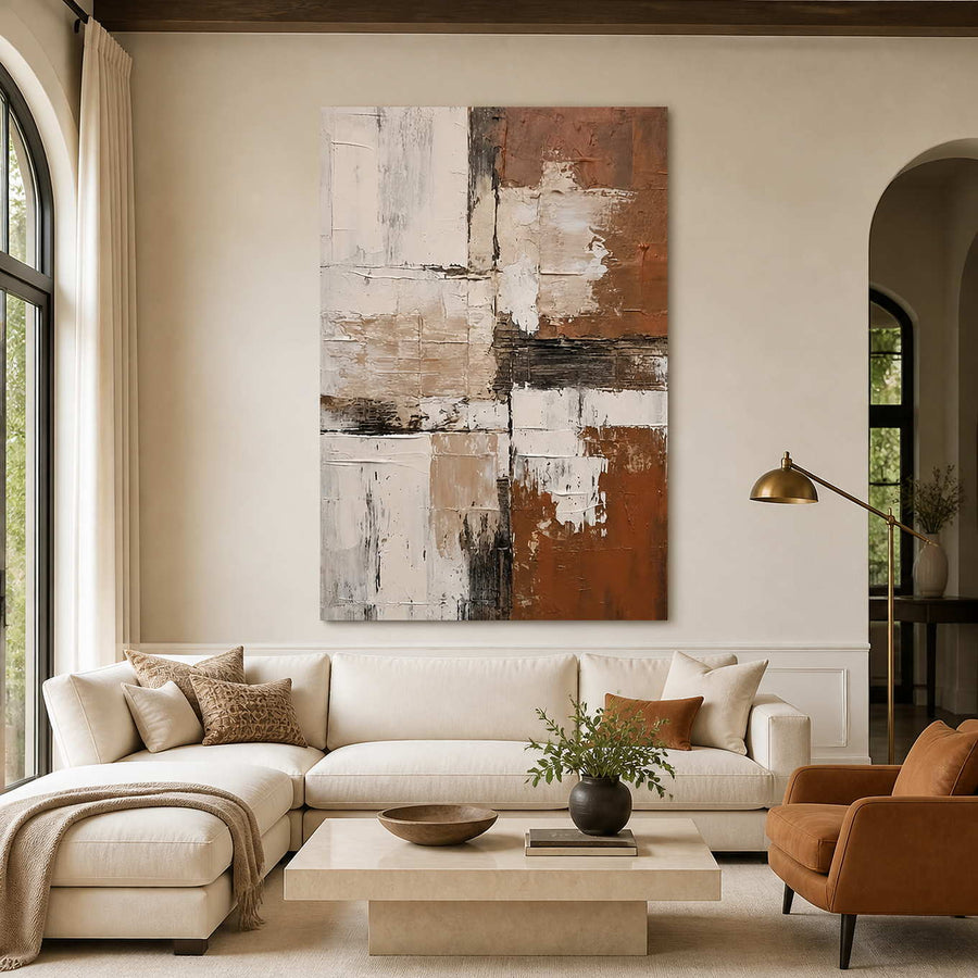Terracotta and cream abstract wall art above a sofa in a warm living room.