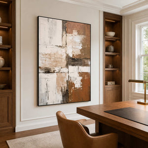 Black-framed textured abstract wall art beside a wooden desk and recessed bookcases.
