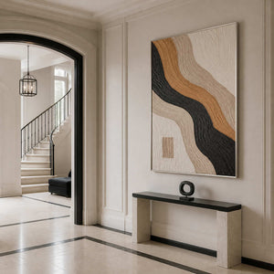 Vertical textured abstract wall art in a bright luxury entryway with a silver metal frame.