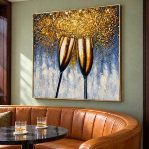Artwork showing two golden champagne flutes leaning together beneath gold-colored speckles on blue gray above curved seating and a drinks table, with a gold-colored frame.