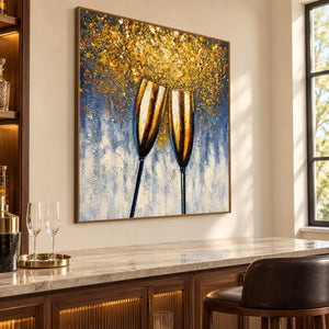 Artwork showing two golden champagne flutes leaning together beneath gold-colored speckles on blue gray above a home bar counter, with a brown wood-look frame.